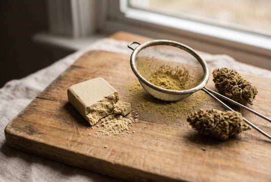 Plaque de pollen de CBD pressé sur une planche en bois, avec un tamis et des fleurs de chanvre
